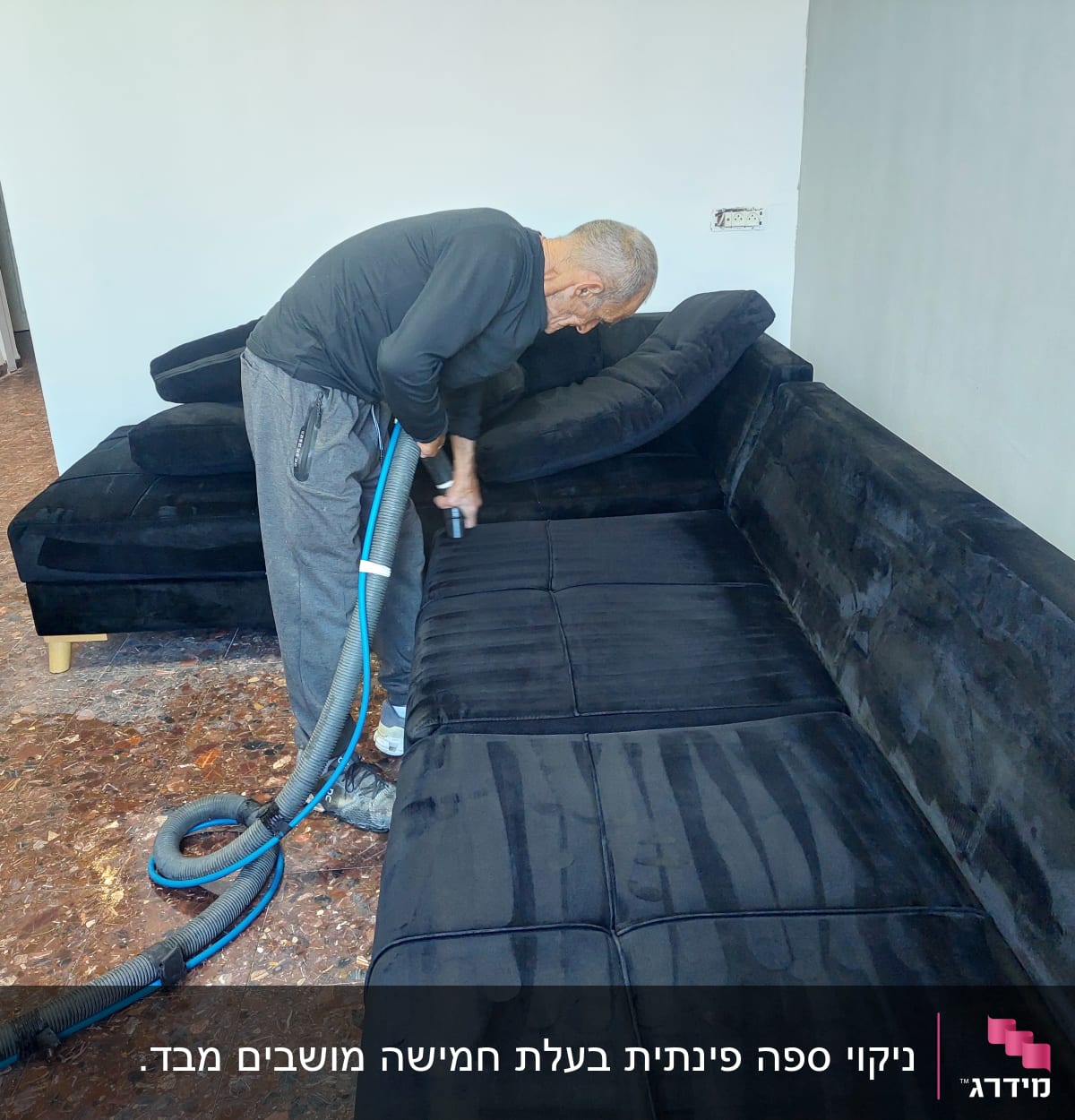 אדם מנקה ספה עם שואב אבק תעשייתי